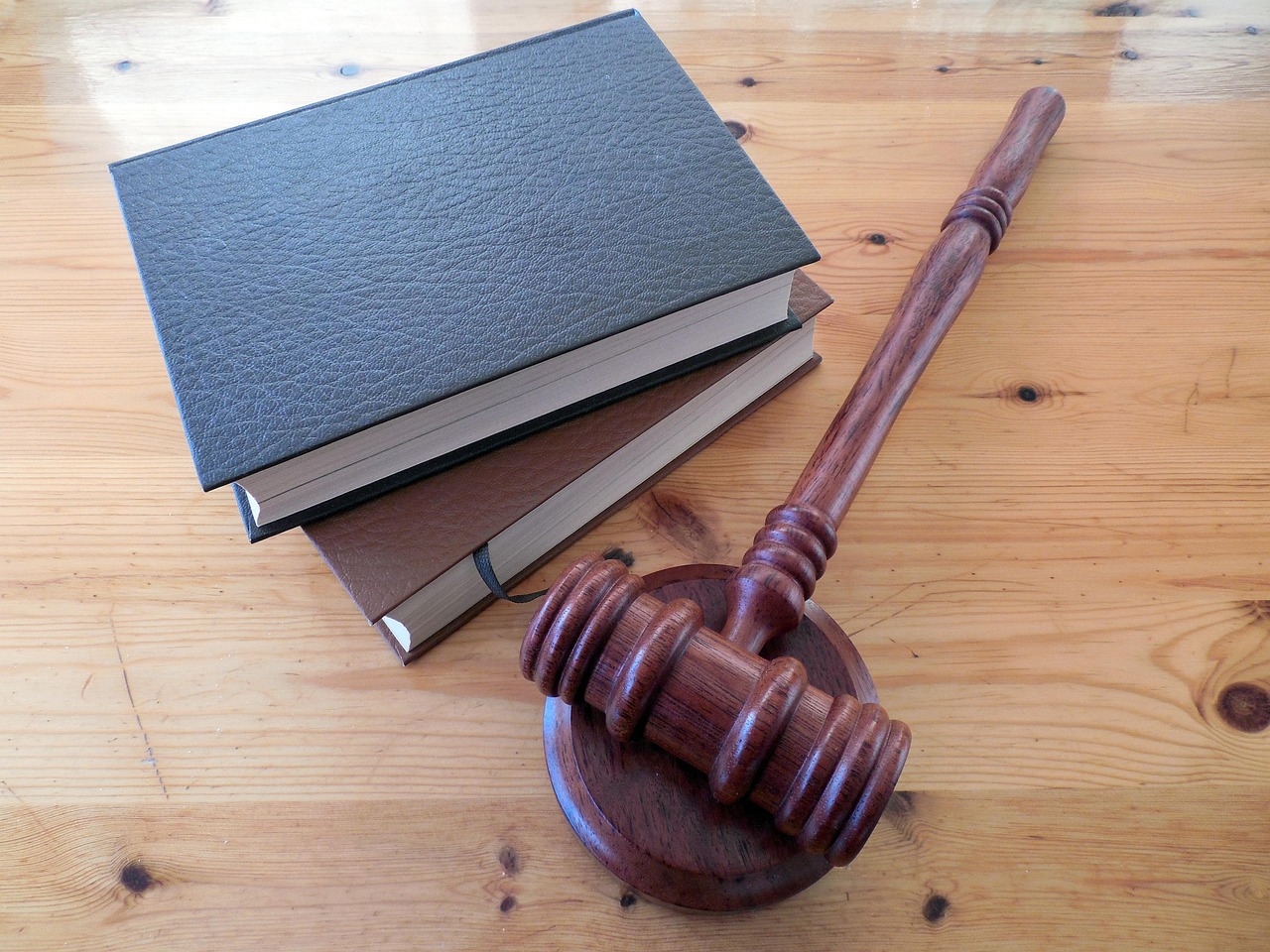 A wooden gavel resting on a stack of law books.
